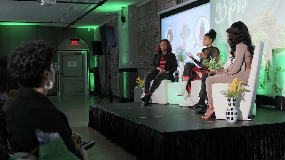 Camera operator with a box lens filming a conference